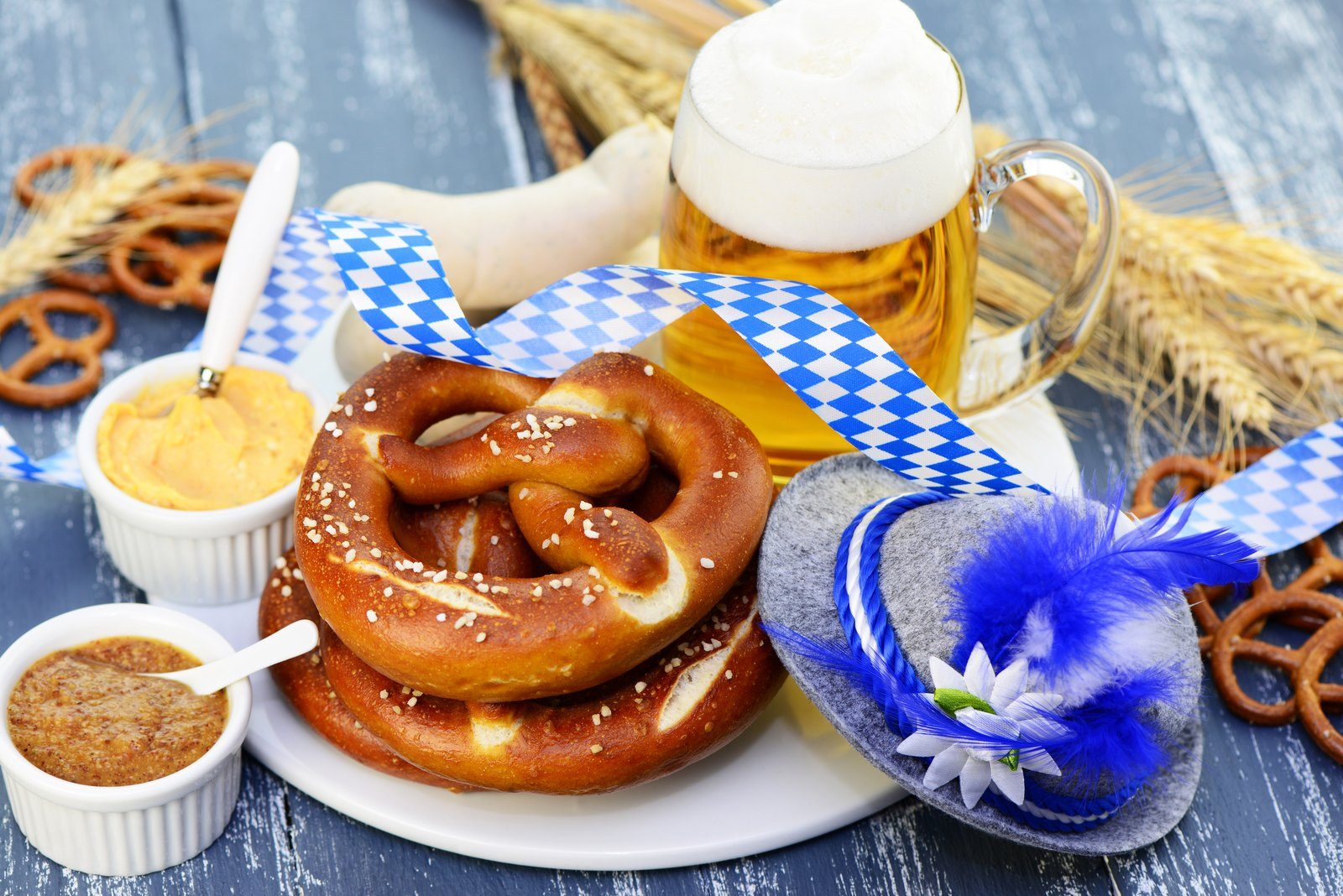 Brezn, Senf und Maßkrug auf einem Tisch mit bayerischer Deko