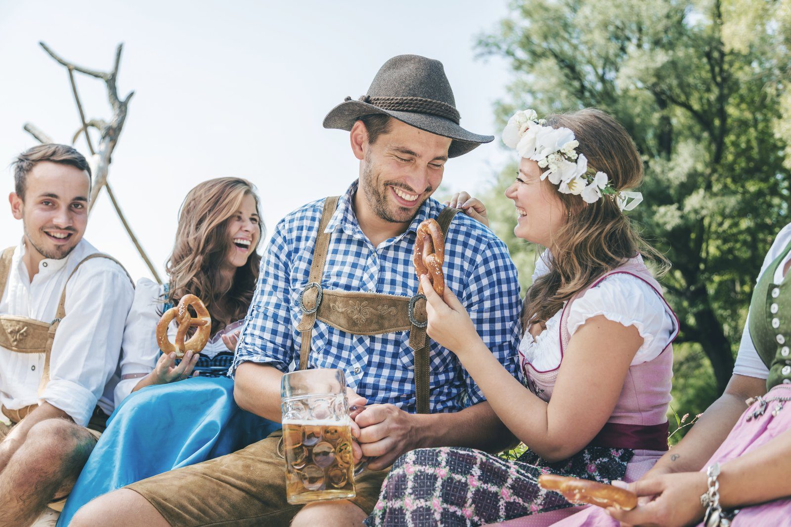 Freunde in Tracht stoßen mit Maßkrügen an
