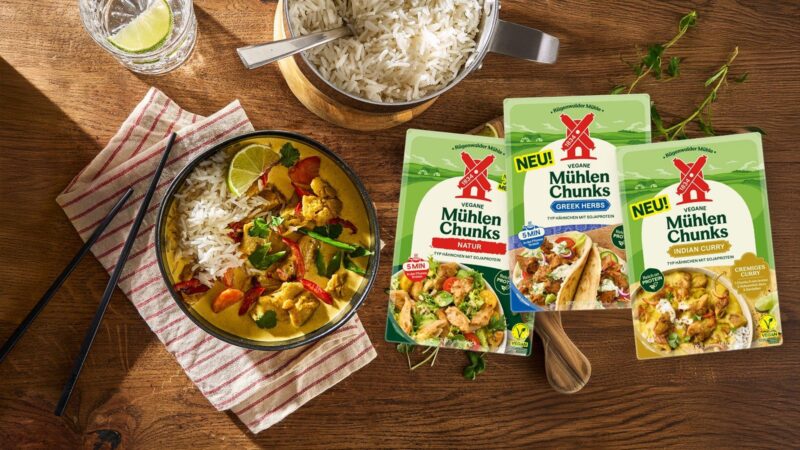 Die drei neuen Veganen Mühlen Chunks von Rügenwalder in den Sorten Natur, Greek Herbs und Indian Curry neben einer Schüssel Curry mit Reis
