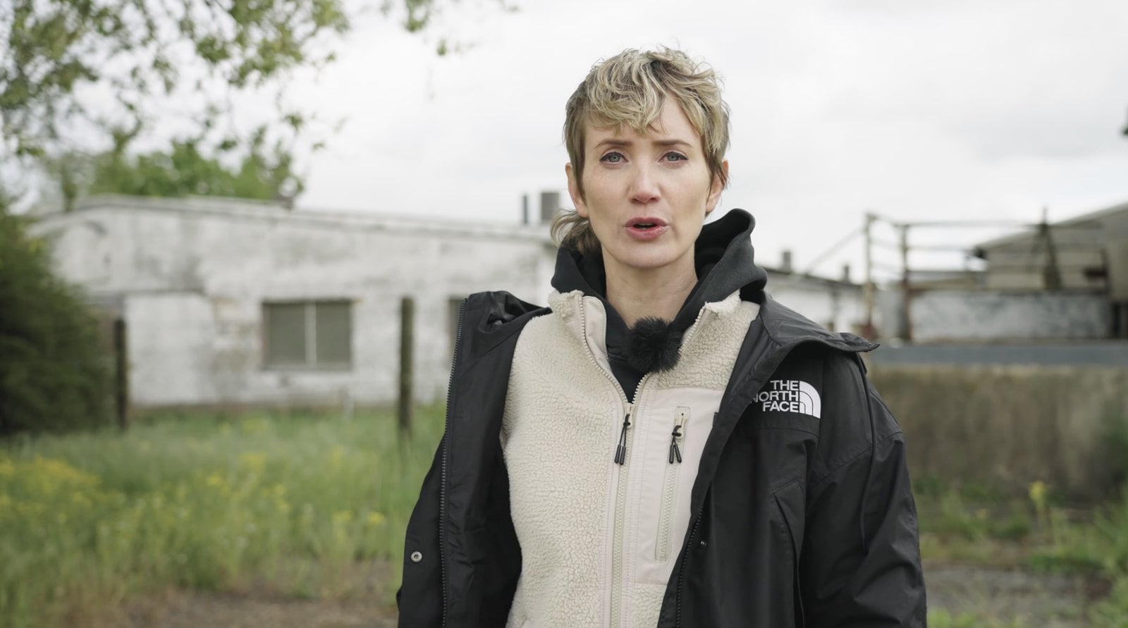 Samara Eckardt steht vor einem Stallgebäude und spricht in die Kamera