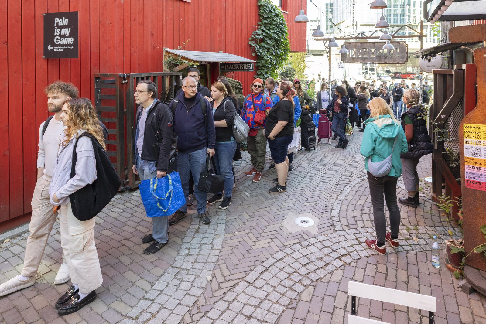 Viele Menschen stehen auf einem Weg am Holzmarkt an