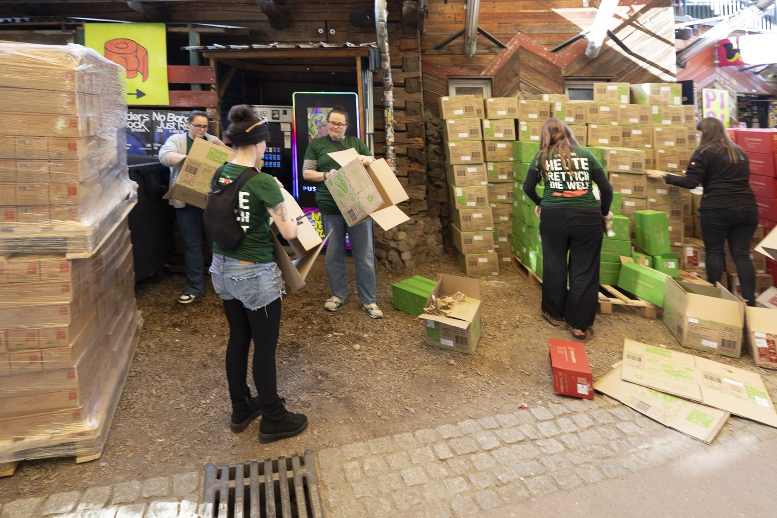 Helfer trägt Kartons mit geretteten Lebensmitteln auf dem Gelände