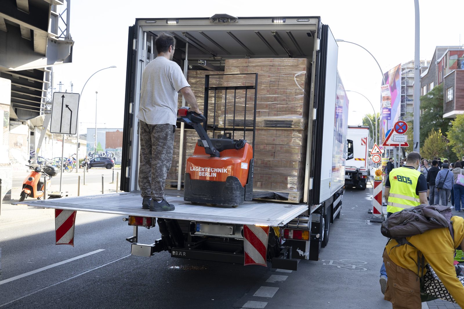Lkw wird mit einem Hubwagen entladen, Paletten mit Kartons