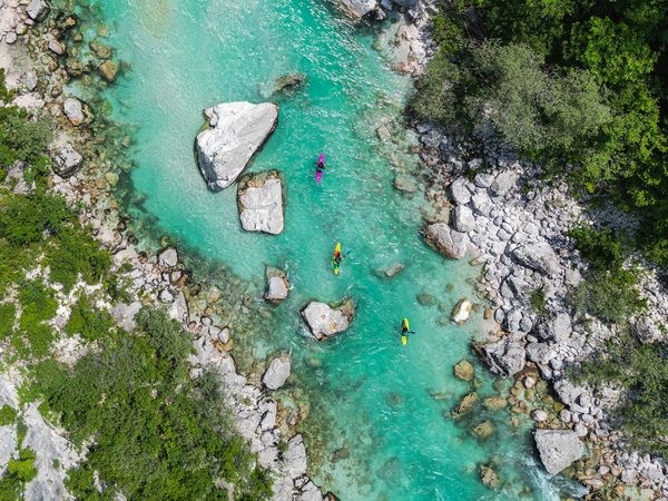 Drei Kajaks auf dem türkisfarbenen Fluss Soča in Slowenien aus der Luft
