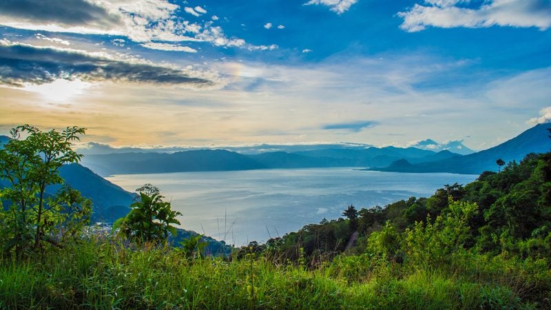 Landschaft in Atitlán-See: Blick über den Atitlán-See mit Vulkanen am Horizont in Guatemala