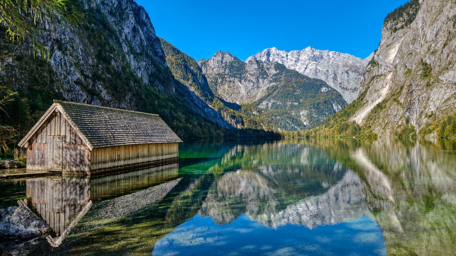 Landschaft in Berchtesgadener Land: Bootshütte am Obersee mit spiegelnden Felswänden