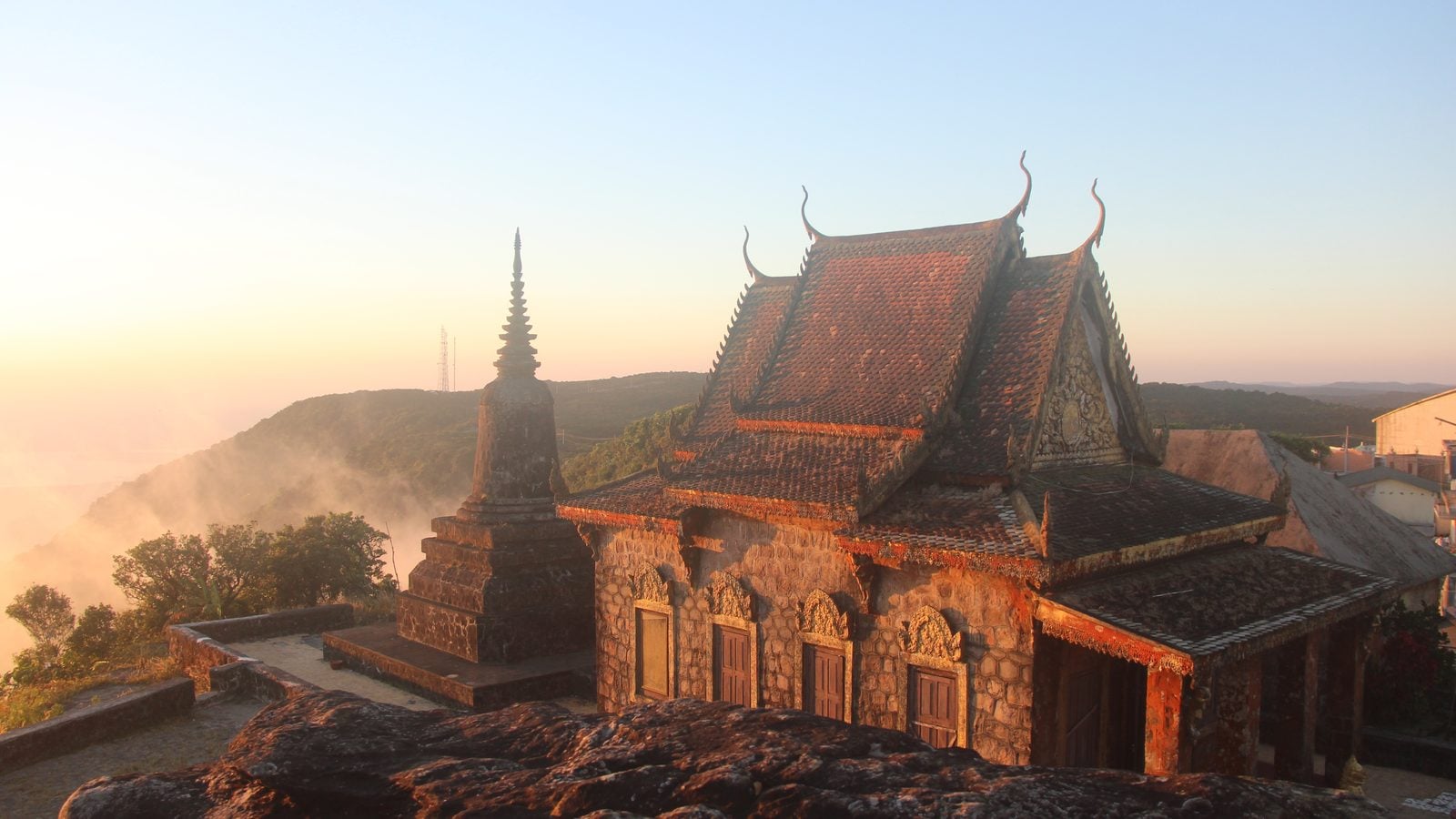 Landschaft in Kampot: Khmer-Tempel auf dem Bokor-Berg über Nebel und Hügeln im Abendlicht