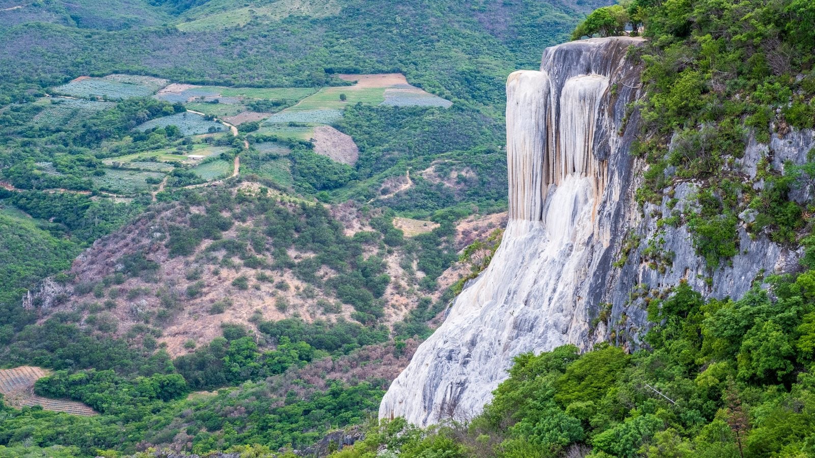 Landschaft in Sierra Sur von Oaxaca: Kalksinter-Wasserfall Hierve el Agua und grüne Bergtäler im mexikanischen Bundesstaat Oaxaca