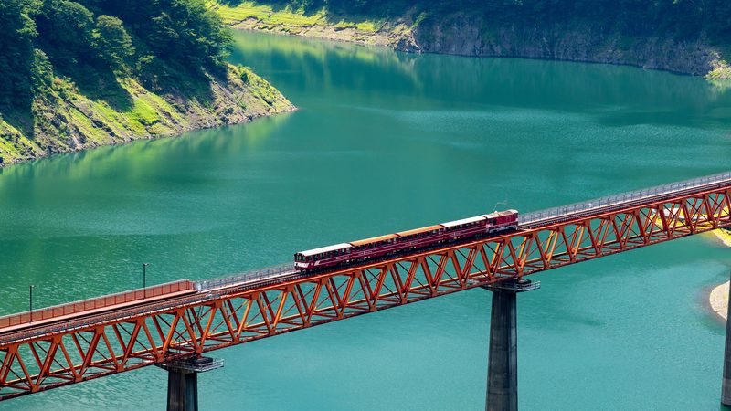 Landschaft in Ōigawa-Tal: Okuōi-Regenbogenbrücke der Ōigawa-Bahn über den türkisen Stausee in den Bergen von Shizuoka