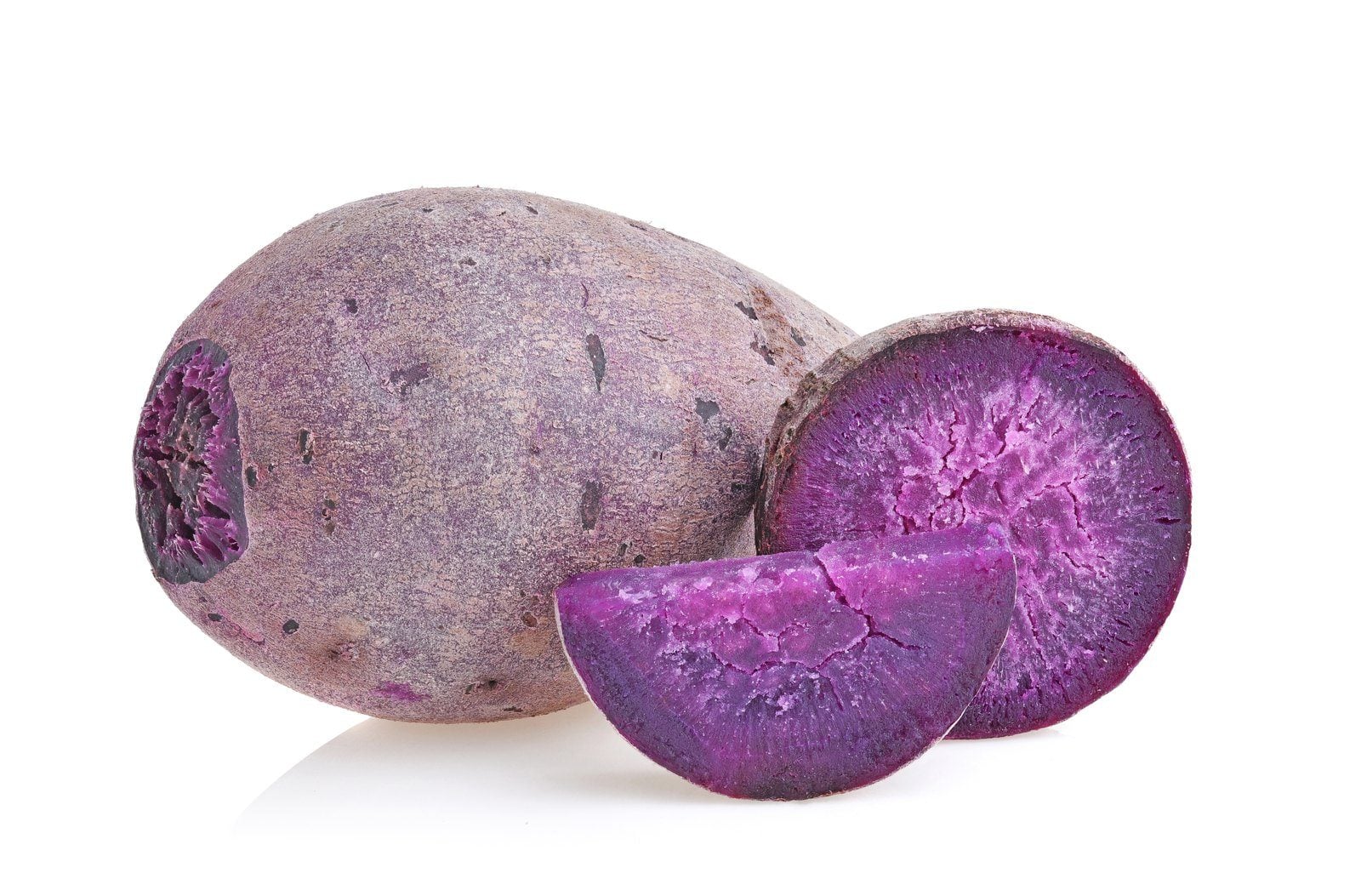 Violette Yamswurzel Ube, ganz und aufgeschnitten, das Fruchtfleisch leuchtet kräftig lila