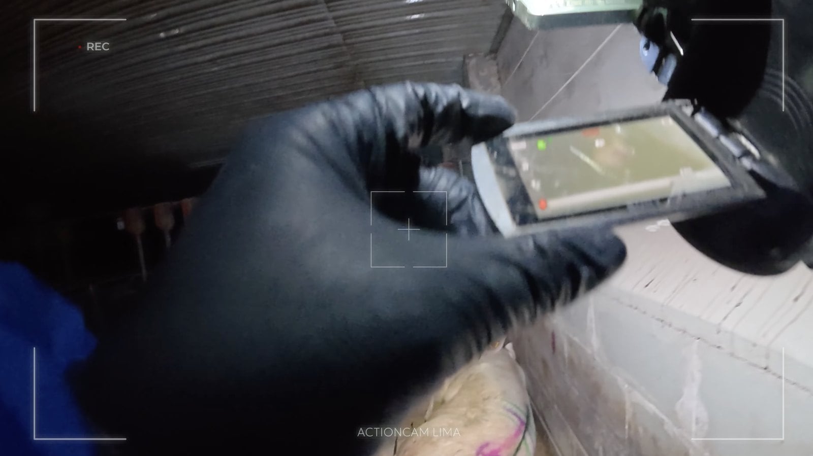 Actioncam-Aufnahme aus dem Film, eine behandschuhte Hand bedient einen kleinen Monitor