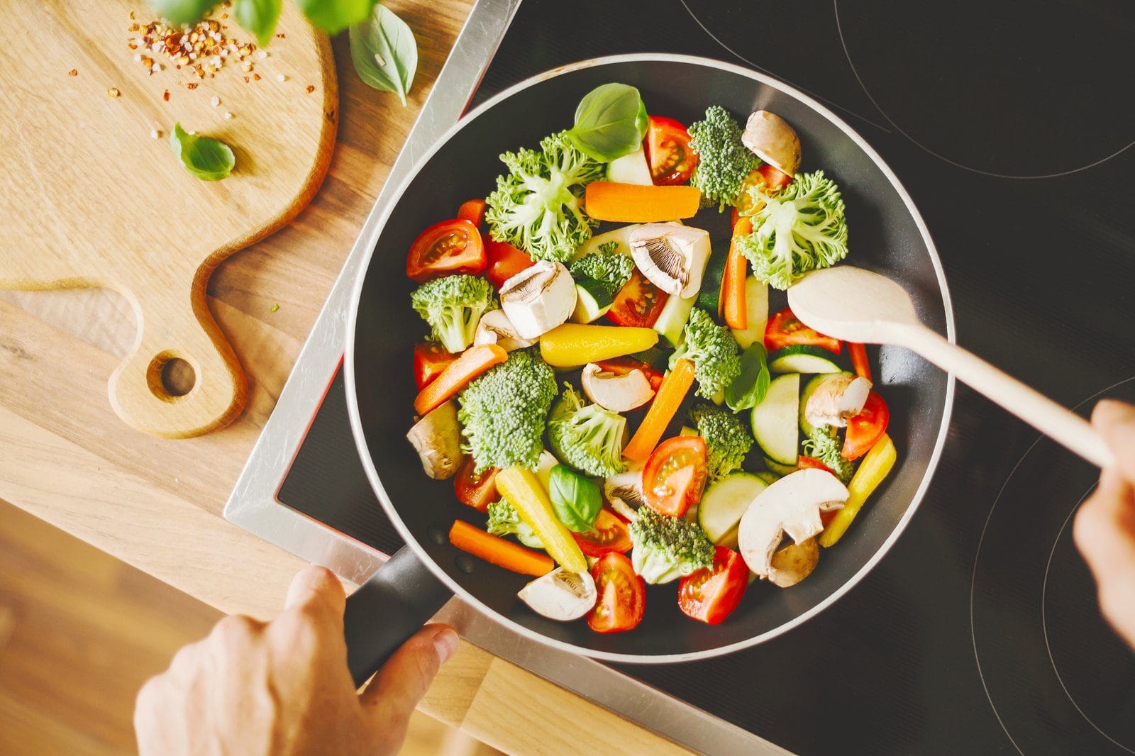 Gemüsepfanne mit Brokkoli und Paprika wird zubereitet, fettarm gekocht