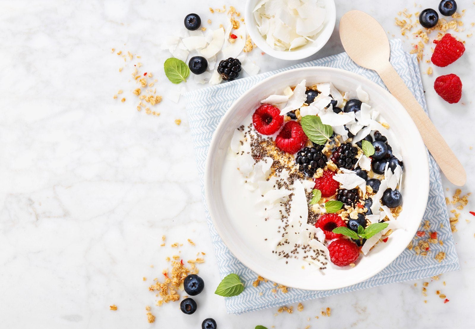 Pflanzlicher Joghurt mit Beeren und Granola in einer Schale