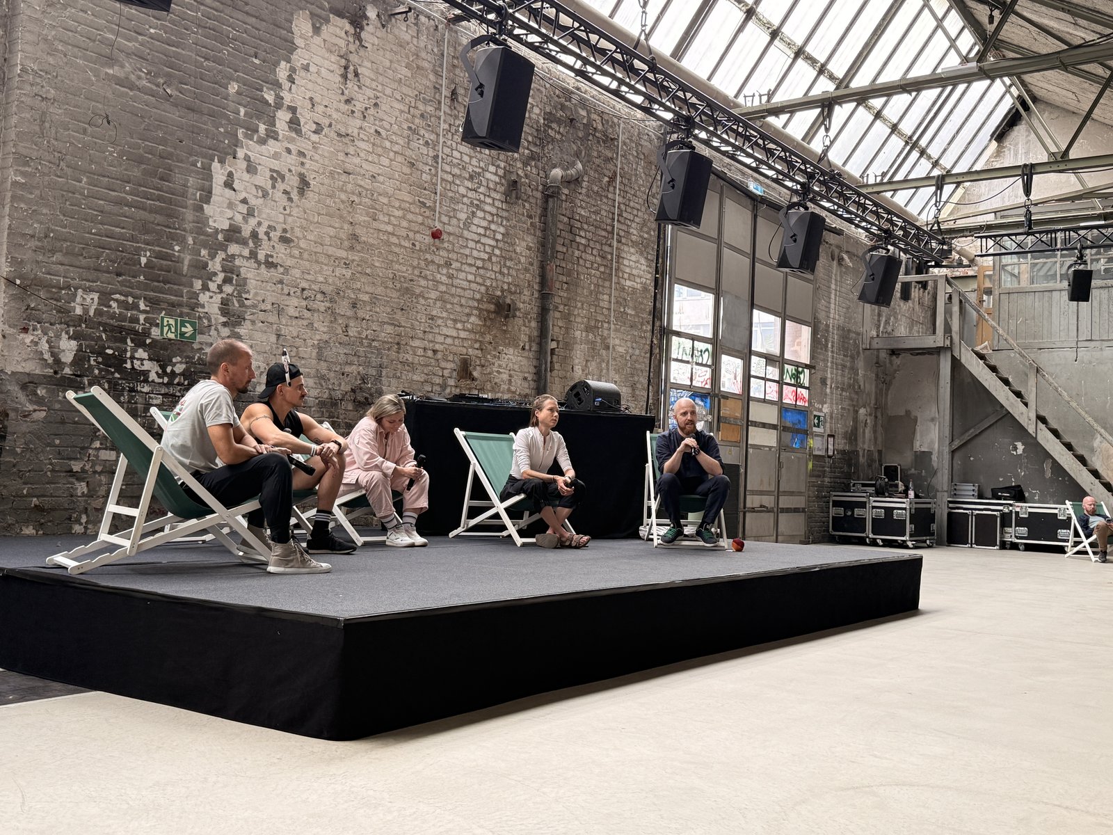 Fünf Panelgäste sitzen in Liegestühlen auf der Bühne beim Panel Vegane Kräfte bündeln