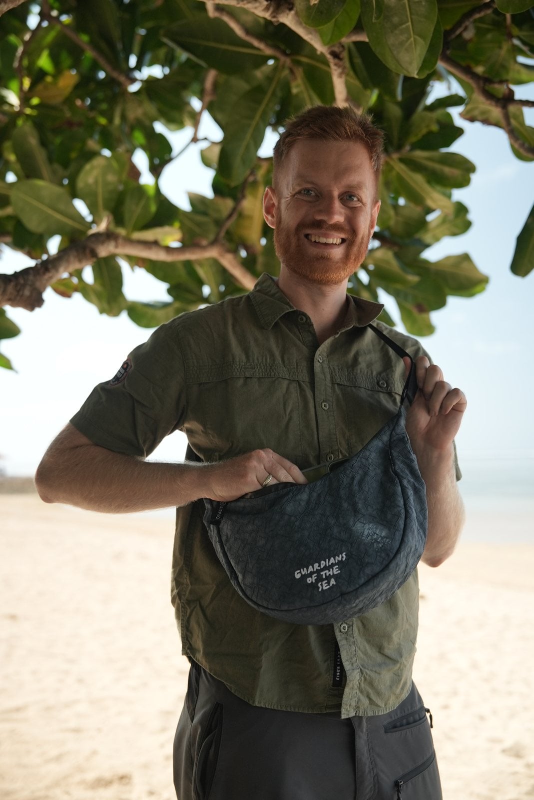 Manuel Bergmann hält den Turtle Moonbaq Mini am Strand