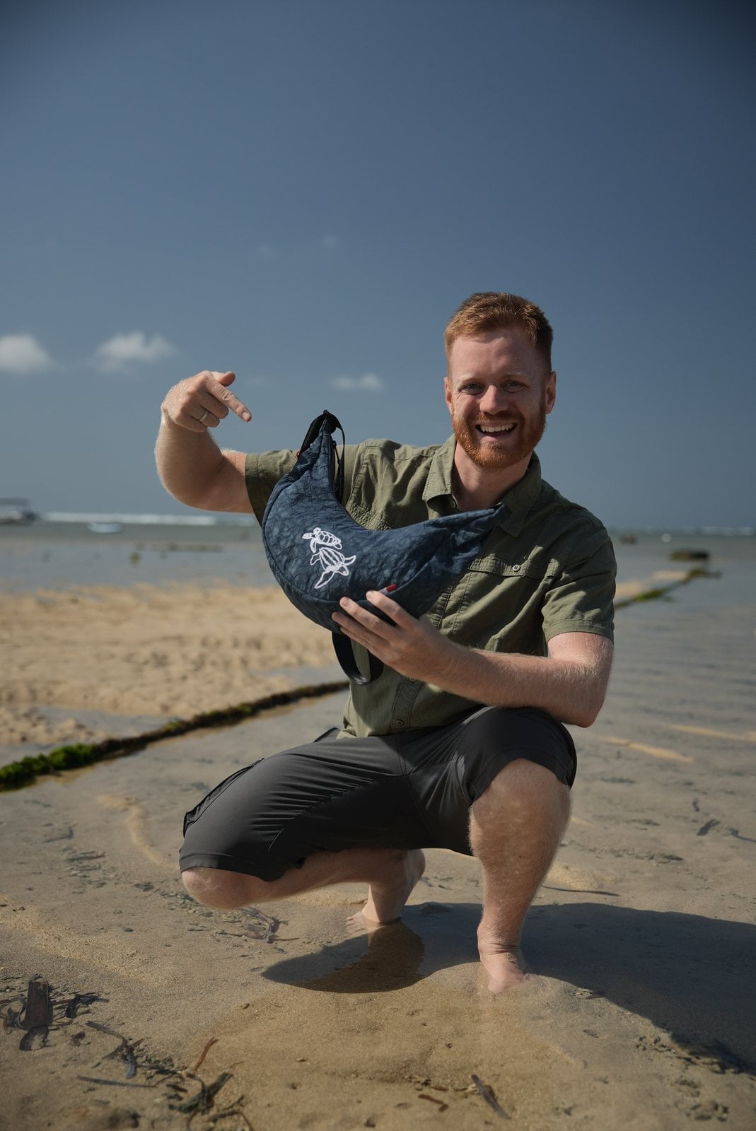 Manuel Bergmann zeigt lachend auf den Turtle Moonbaq Mini