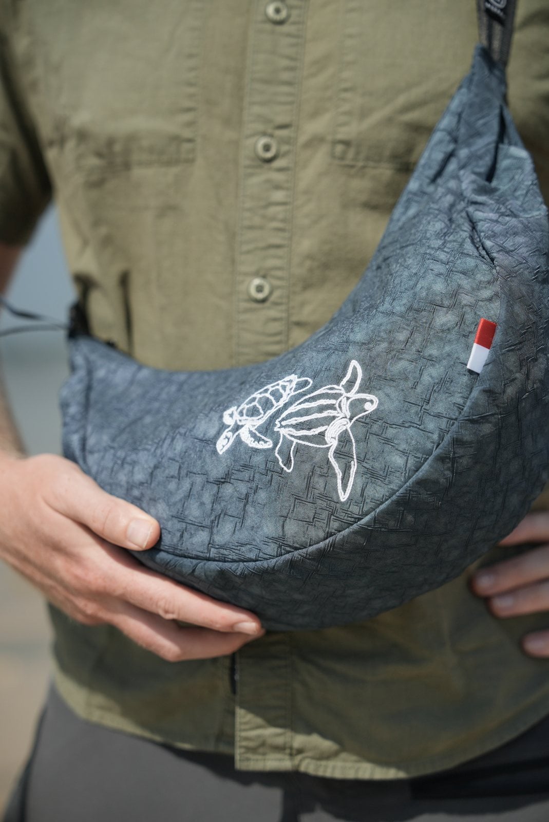 Blaue Umhängetasche Turtle Moonbaq Mini mit weißer Schildkröten-Stickerei