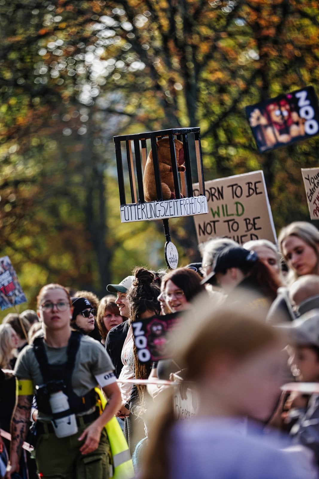 Demonstrierende mit einem Käfigmodell und Schildern