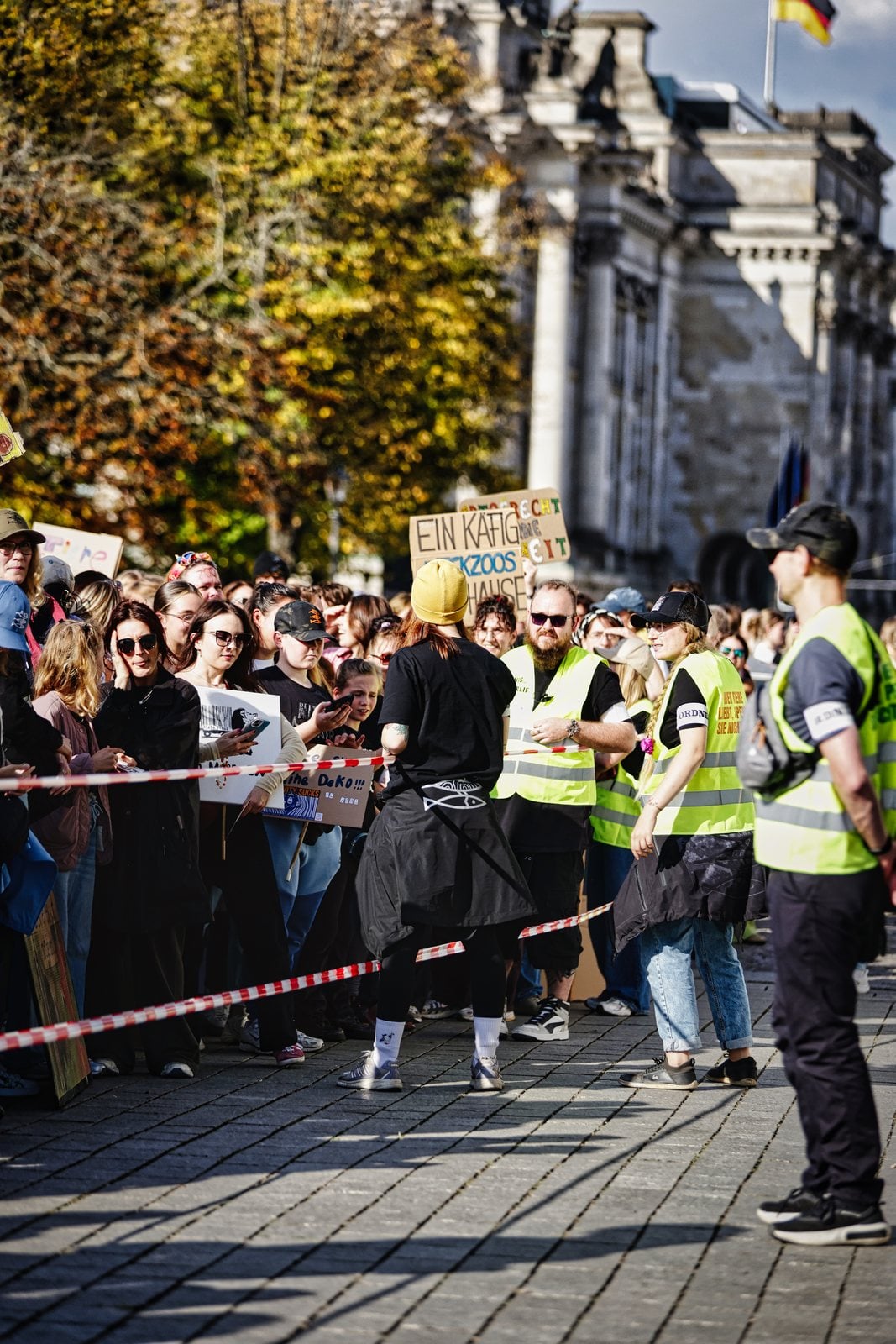 Ordnerinnen und Ordner in Warnwesten vor den Demonstrierenden