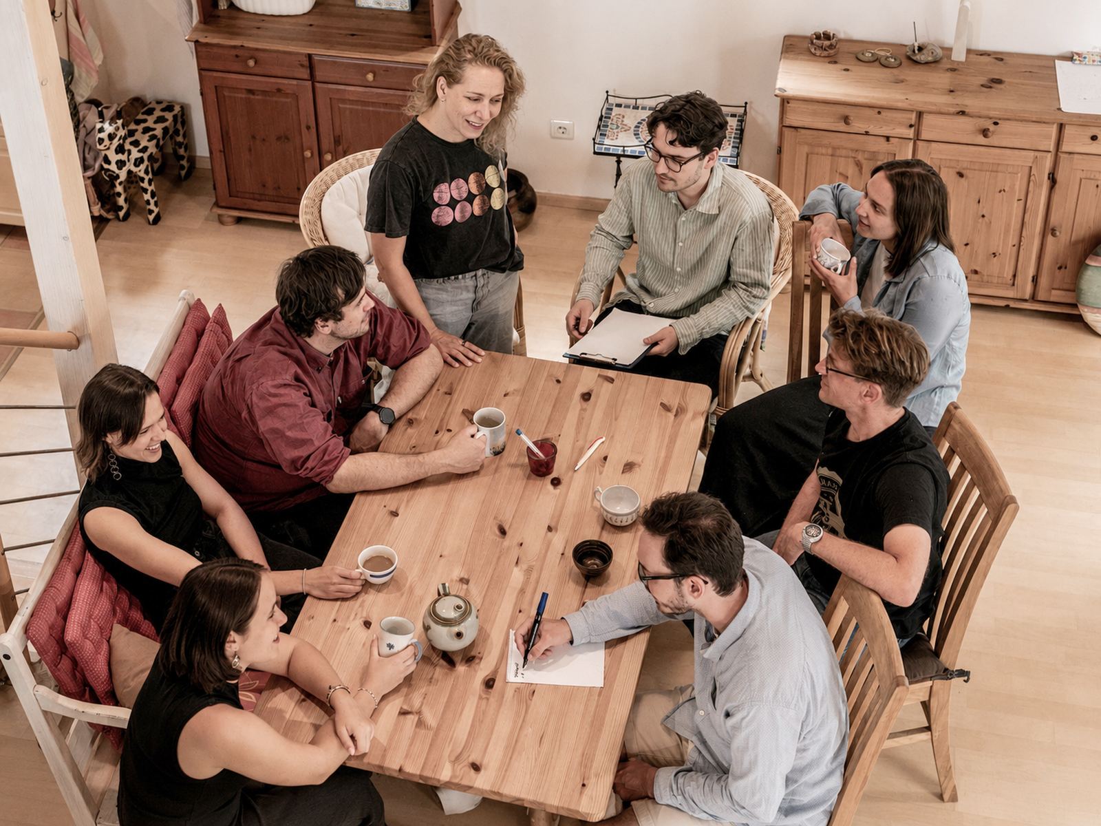Mitglieder des Good News Teams spielen an einem Holztisch Karten