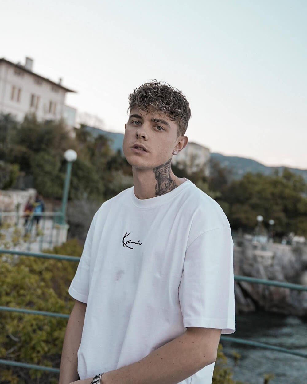 Porträt von Jonas Ems im weißen T-Shirt am Meer