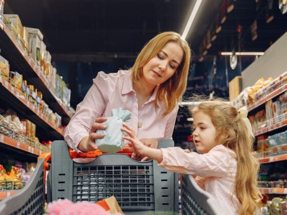 Mutter und Tochter wählen im Supermarktregal ein Produkt aus
