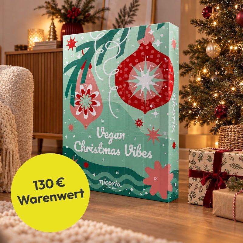 niceria Veganer Adventskalender 2026 „Vegan Christmas Vibes“ vor einem Weihnachtsbaum