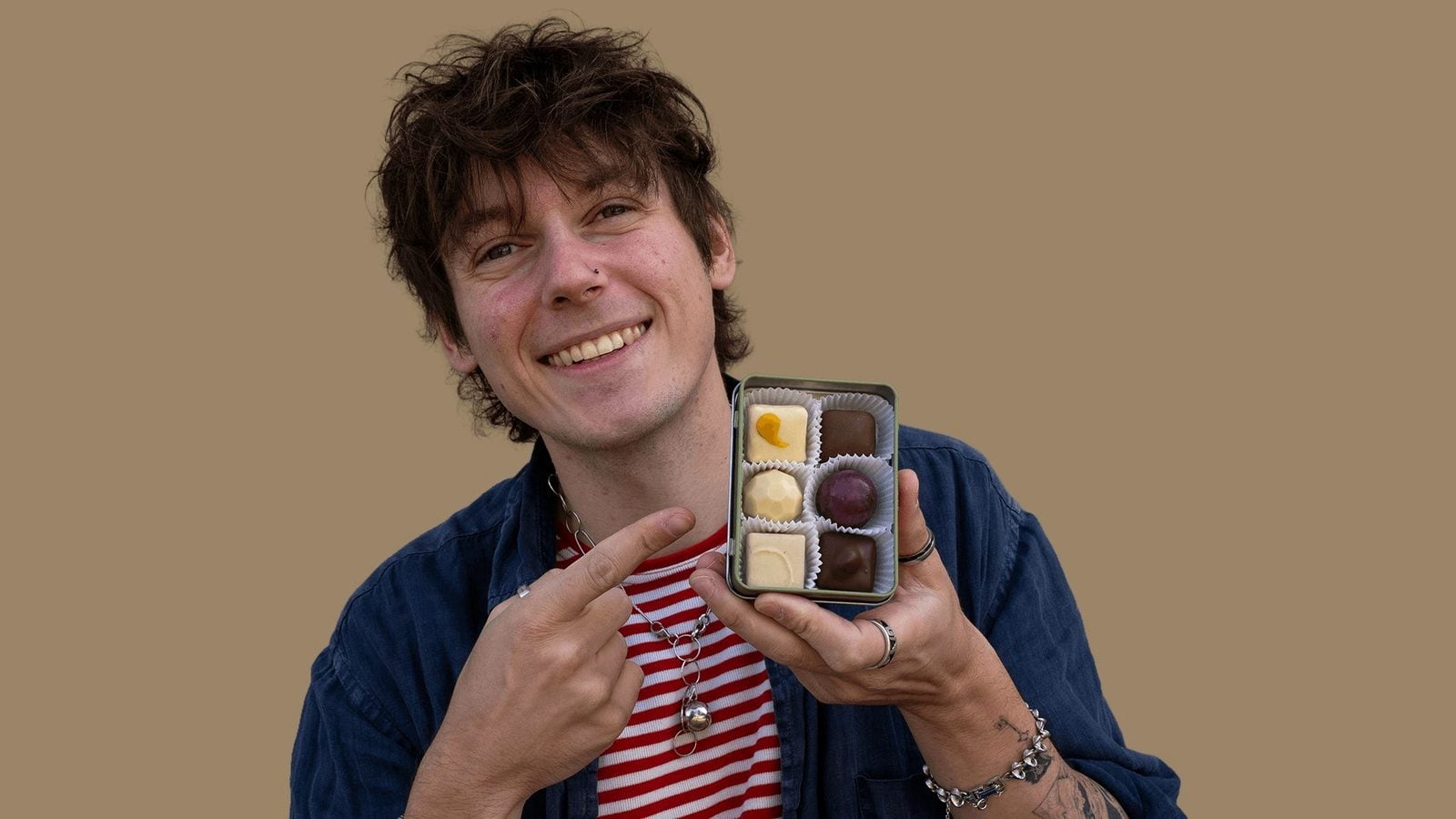 Tobias Wille alias Vegan Veteran zeigt die geöffnete Pralinendose mit sechs Pralinen