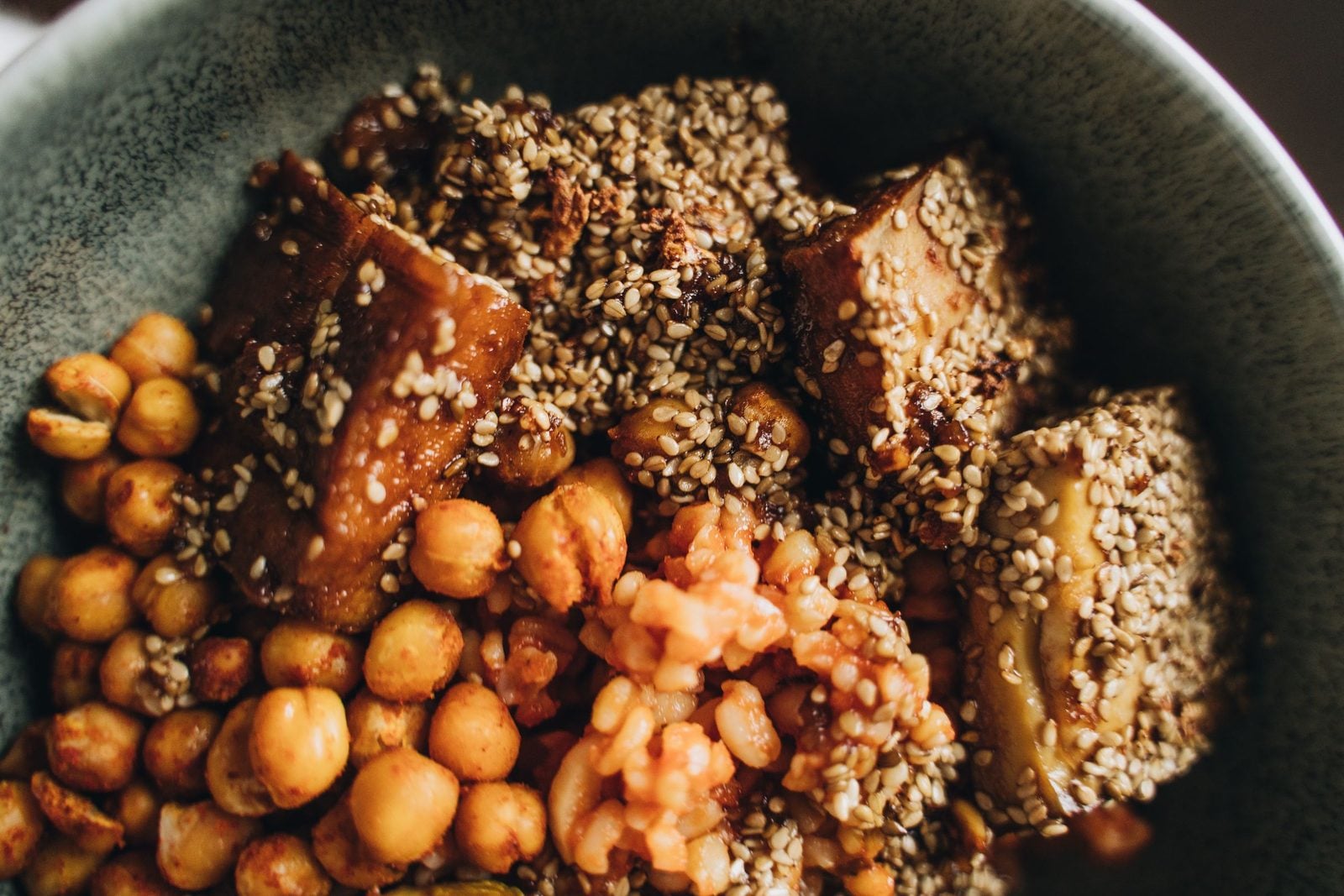 Eine Bowl mit Tofu, Kichererbsen und Sesam von oben