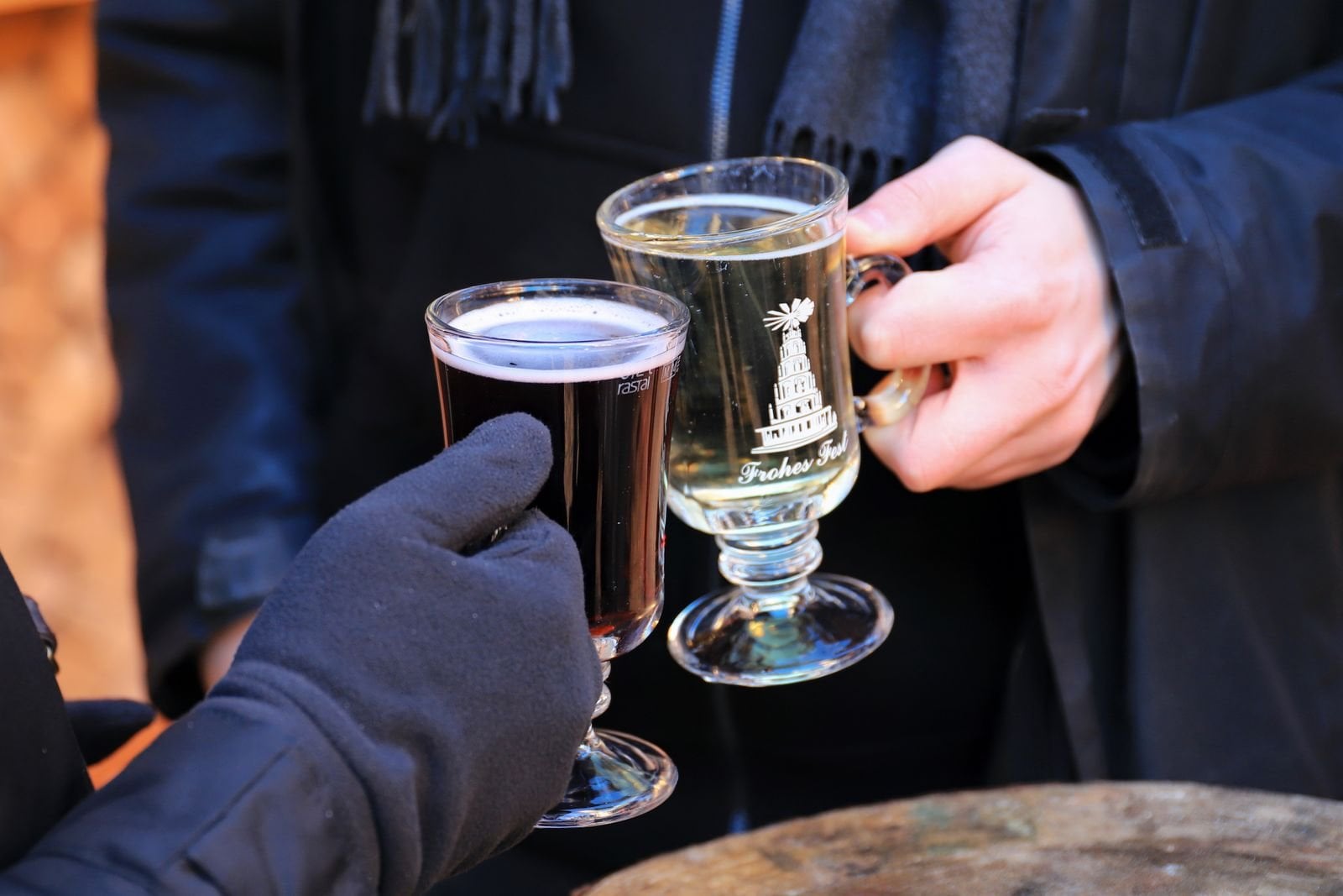 Symbolbild: zwei Tassen Glühwein werden auf einem Weihnachtsmarkt angestoßen
